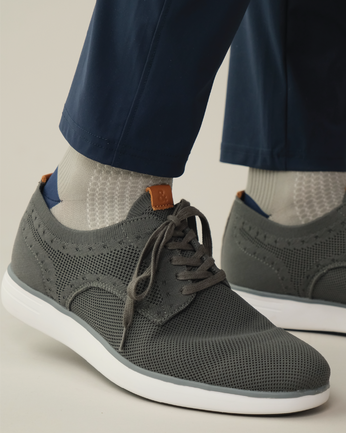 Grey shoe with white outsole worn with midnight navy pants