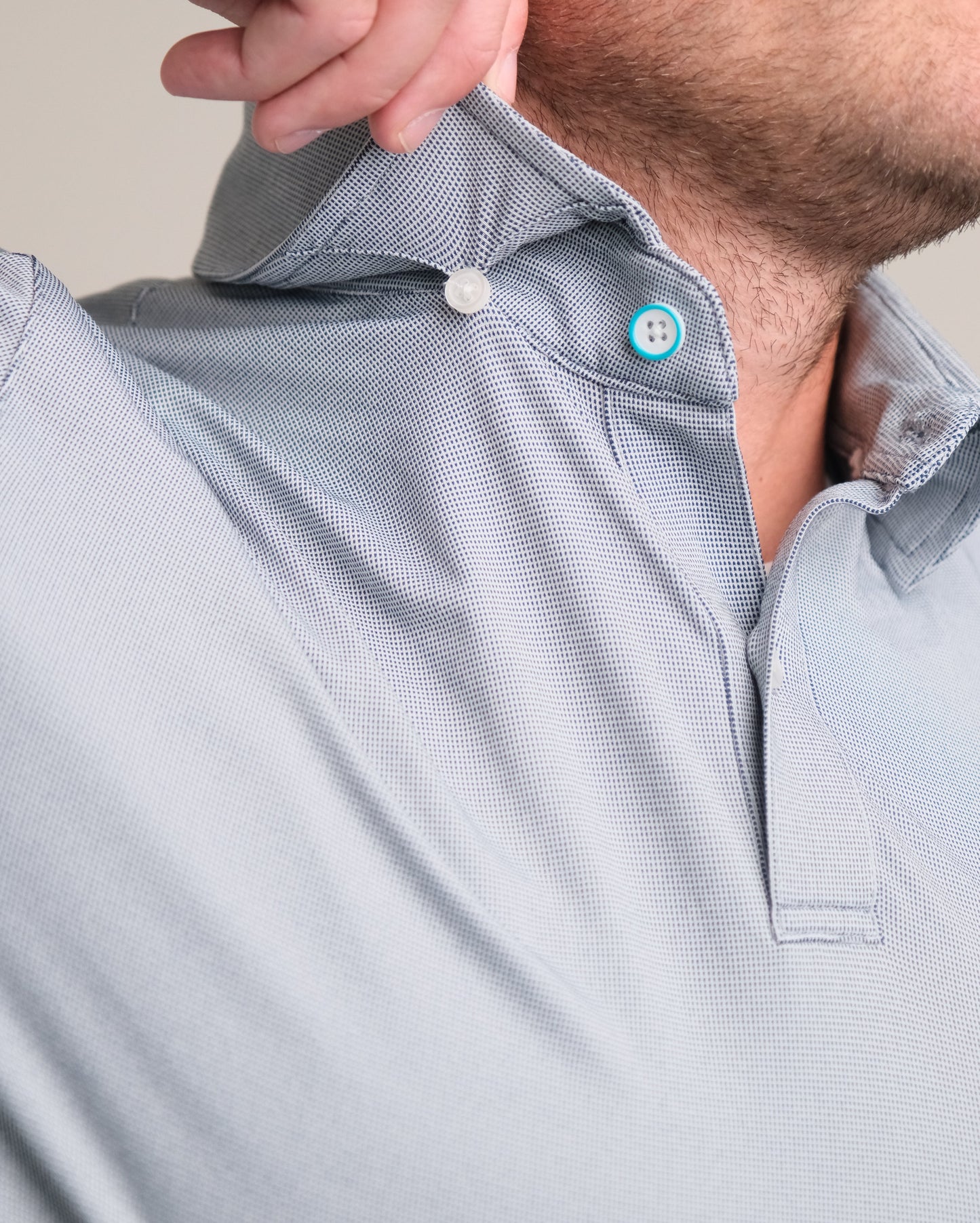 Detail close-up of a steel gray short sleeve polo shirt with buttons hidden button.