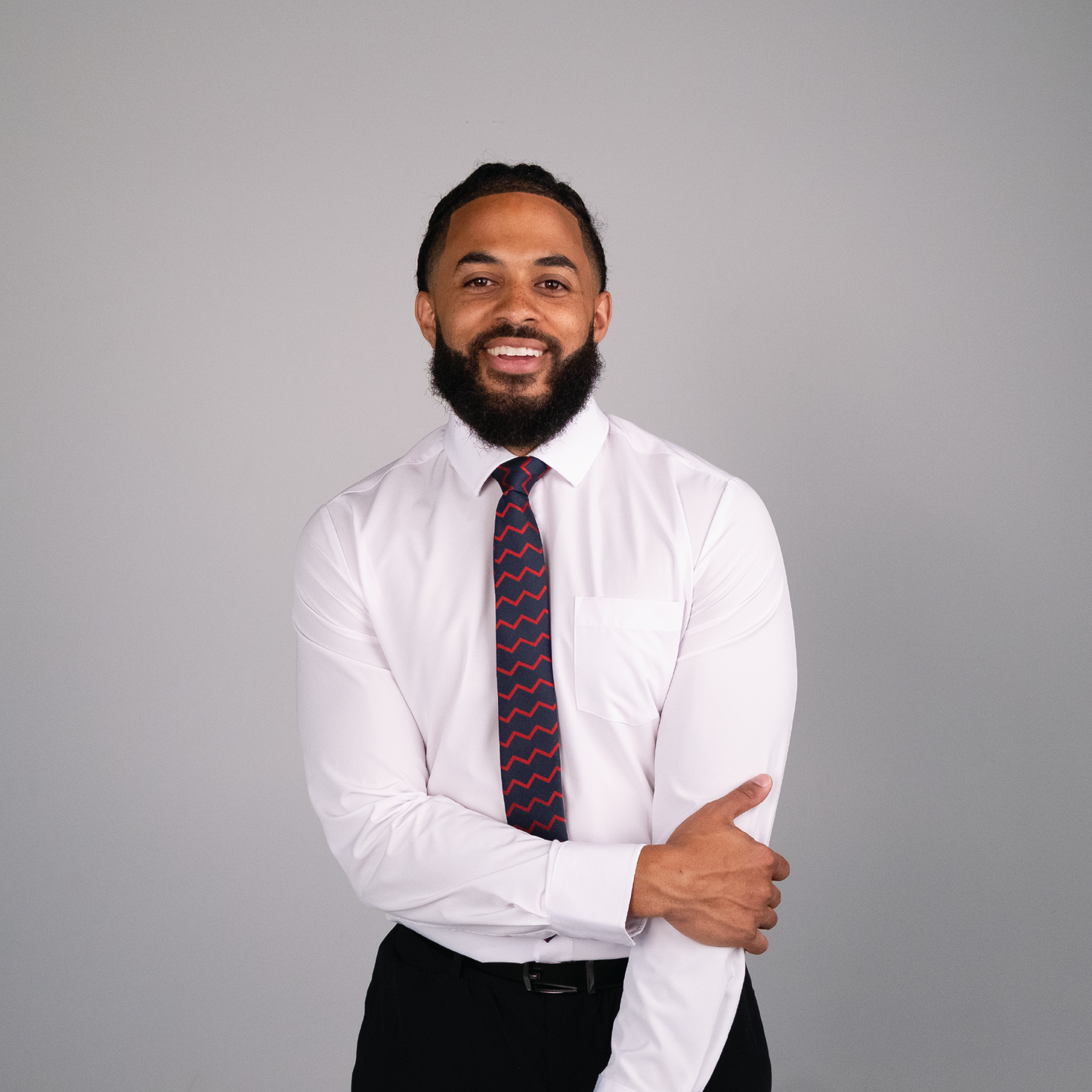 Navy tie with red zigzag pattern on a white dress shirt