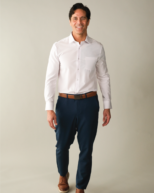 Man wearing a white dress shirt, navy pants, and brown shoes