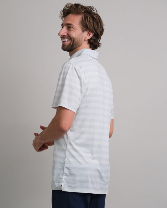 Man wearing a white and gray striped short-sleeve polo shirt 