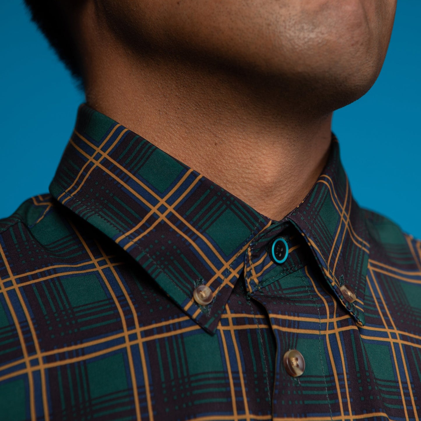 Man wearing Forest Green w/ Burnt Orange and Black Accent. Top button has blue ring.