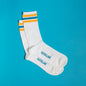 White dress socks with light blue &Collar logo on the bottom, and blue, yellow, and white stripes across the top of the sock.