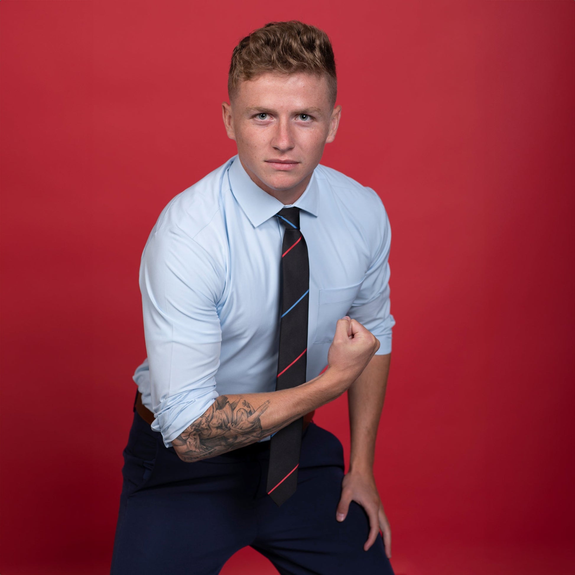 Black tie with blue and red stripes on blue shirt.